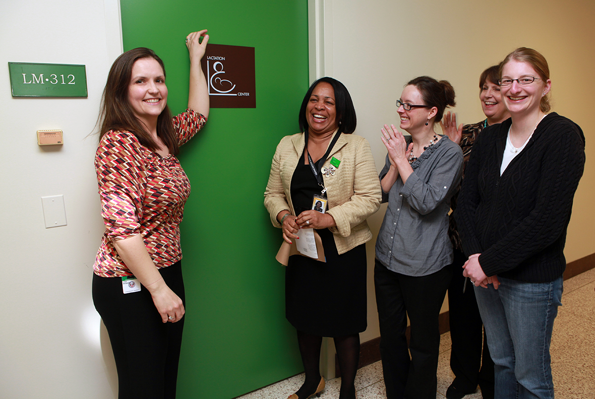 photo shows five women standing in front of the newly opened Lactation Center in the Madison Building